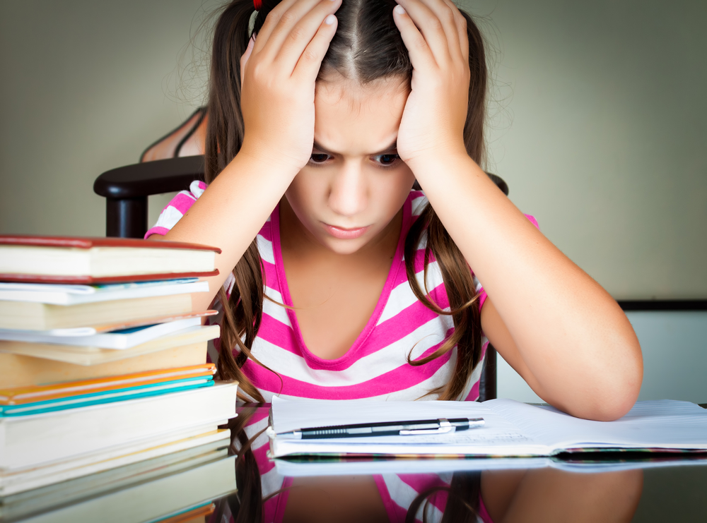 ngry tired school girl with head in hands