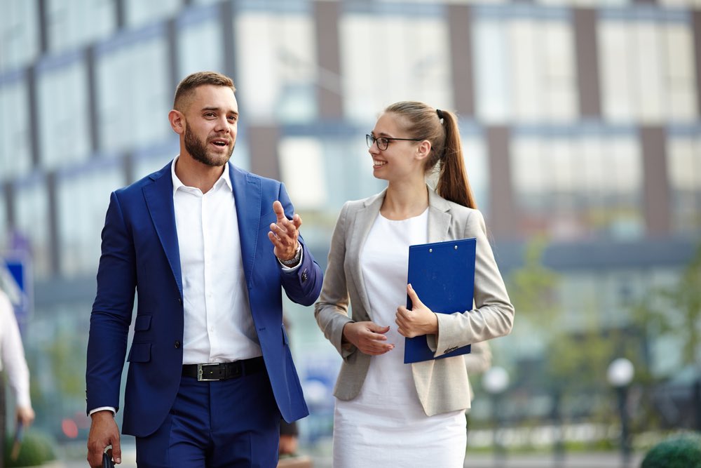 Delegating Communicating Young Male and Female Businessmen Communicating Smiling