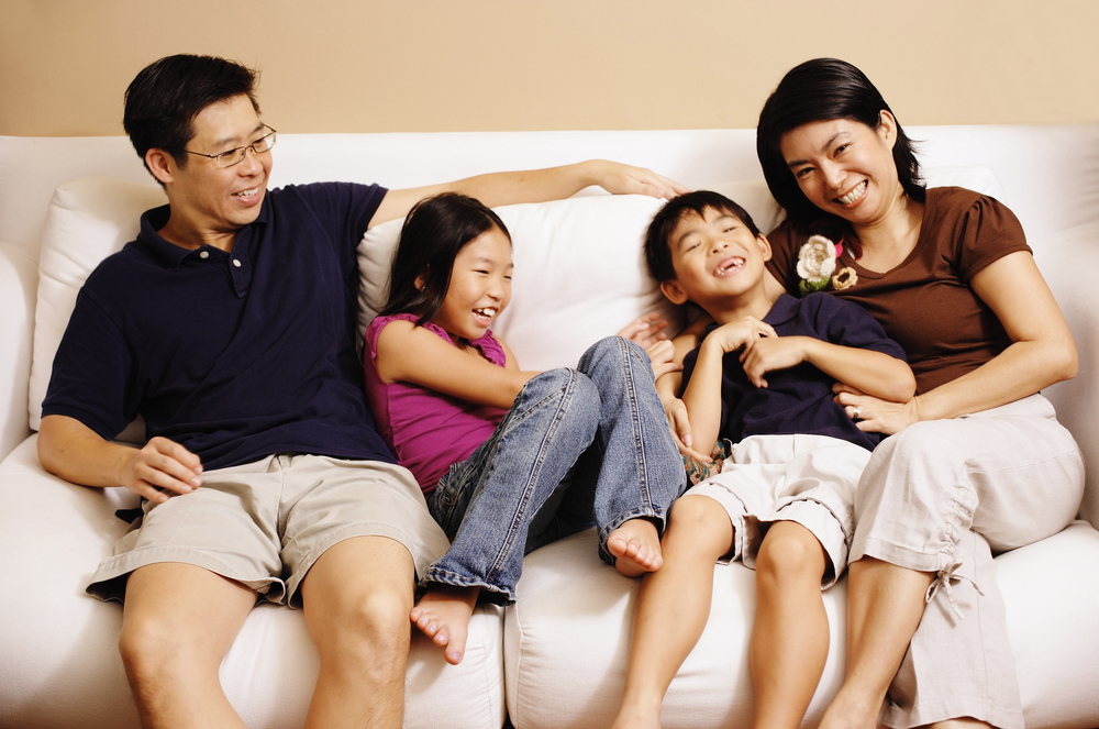 Family of Four Laughing on Sofa