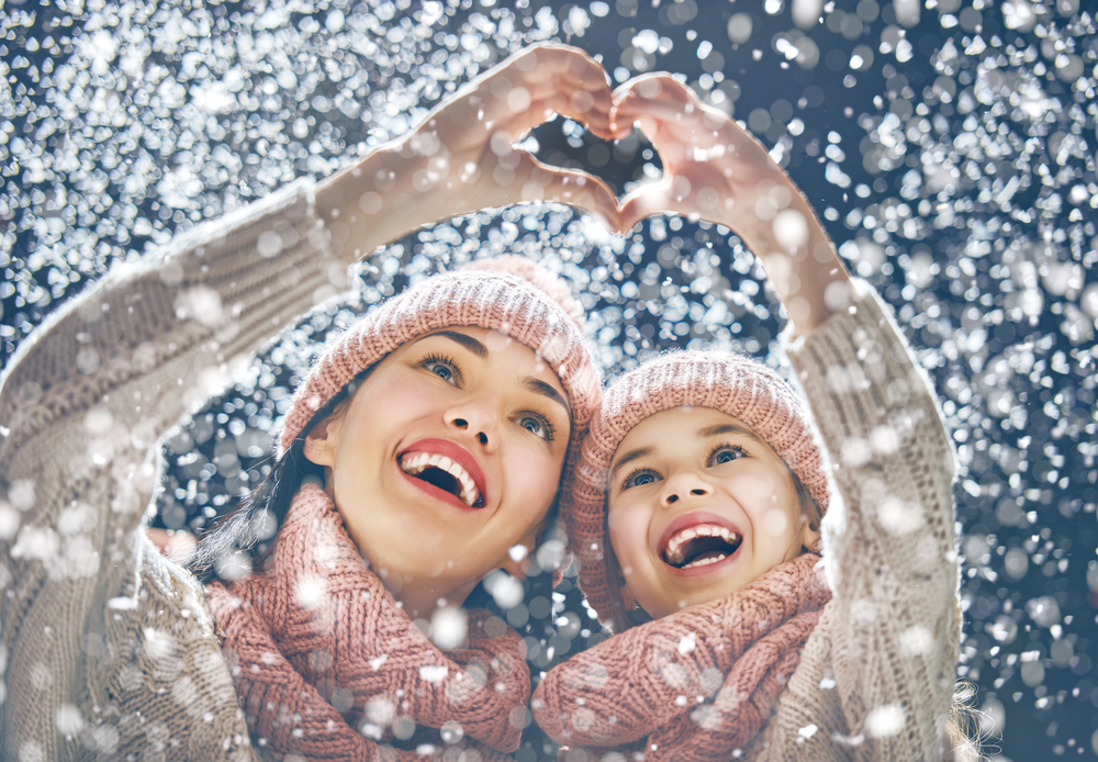 Mom and Daughter in Snow Mom and Daughter in Snow Making Heart with Hands