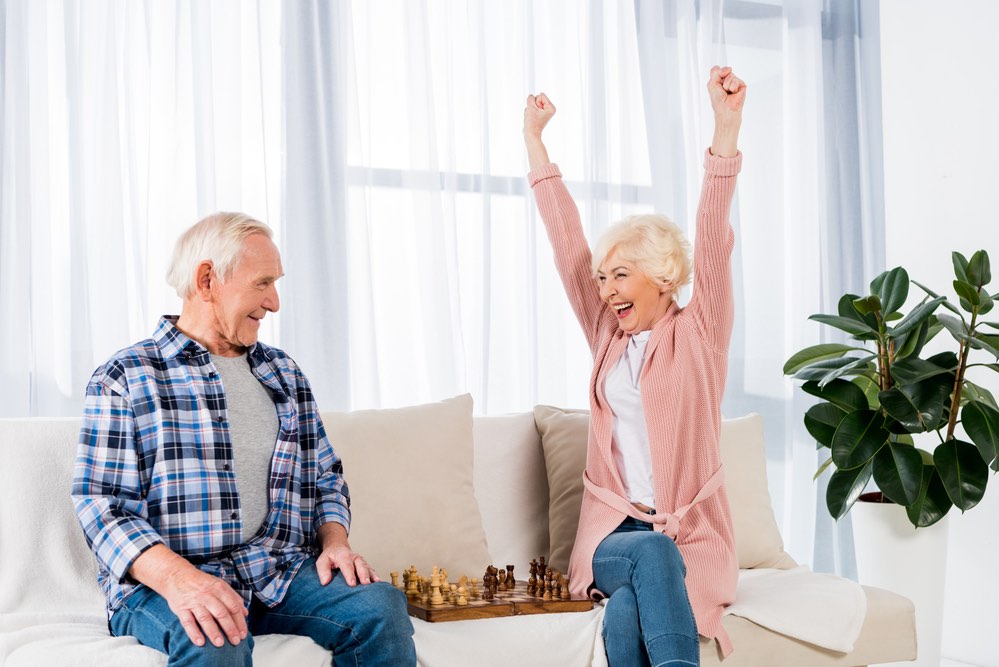 Happy Senior Couple Playing Chess Woman Victorious