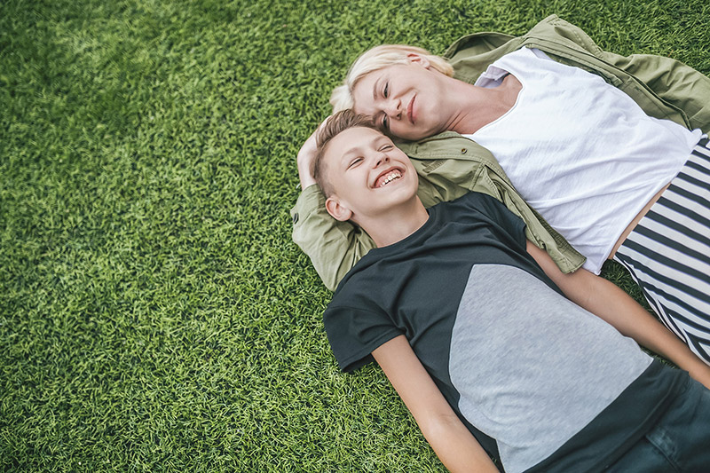 Talk to Kids About ADHD - Mother and Son Lying on Grass Mother and Son Talk Lying on Grass